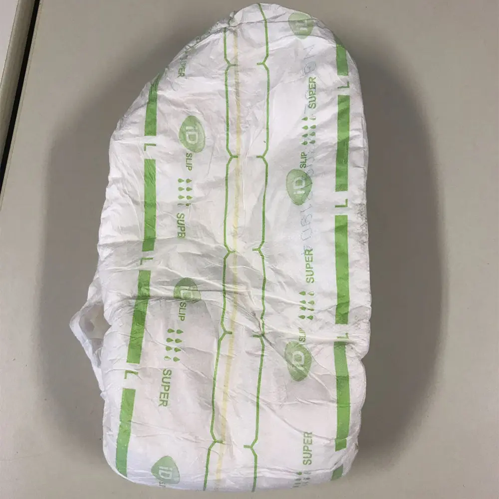 White adult diaper with green markings and size L printed on it, placed on a light surface.
