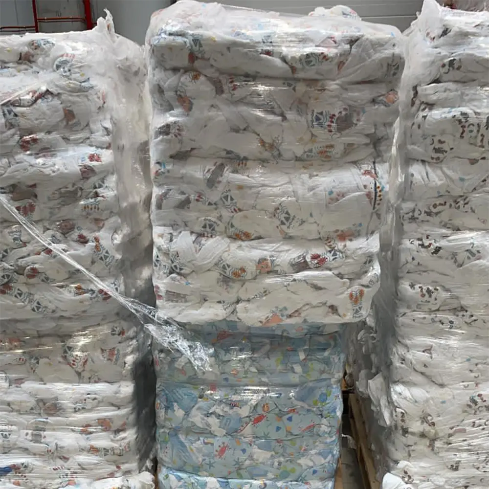 Stacks of baby diapers wrapped in transparent plastic and stacked on pallets in a warehouse.