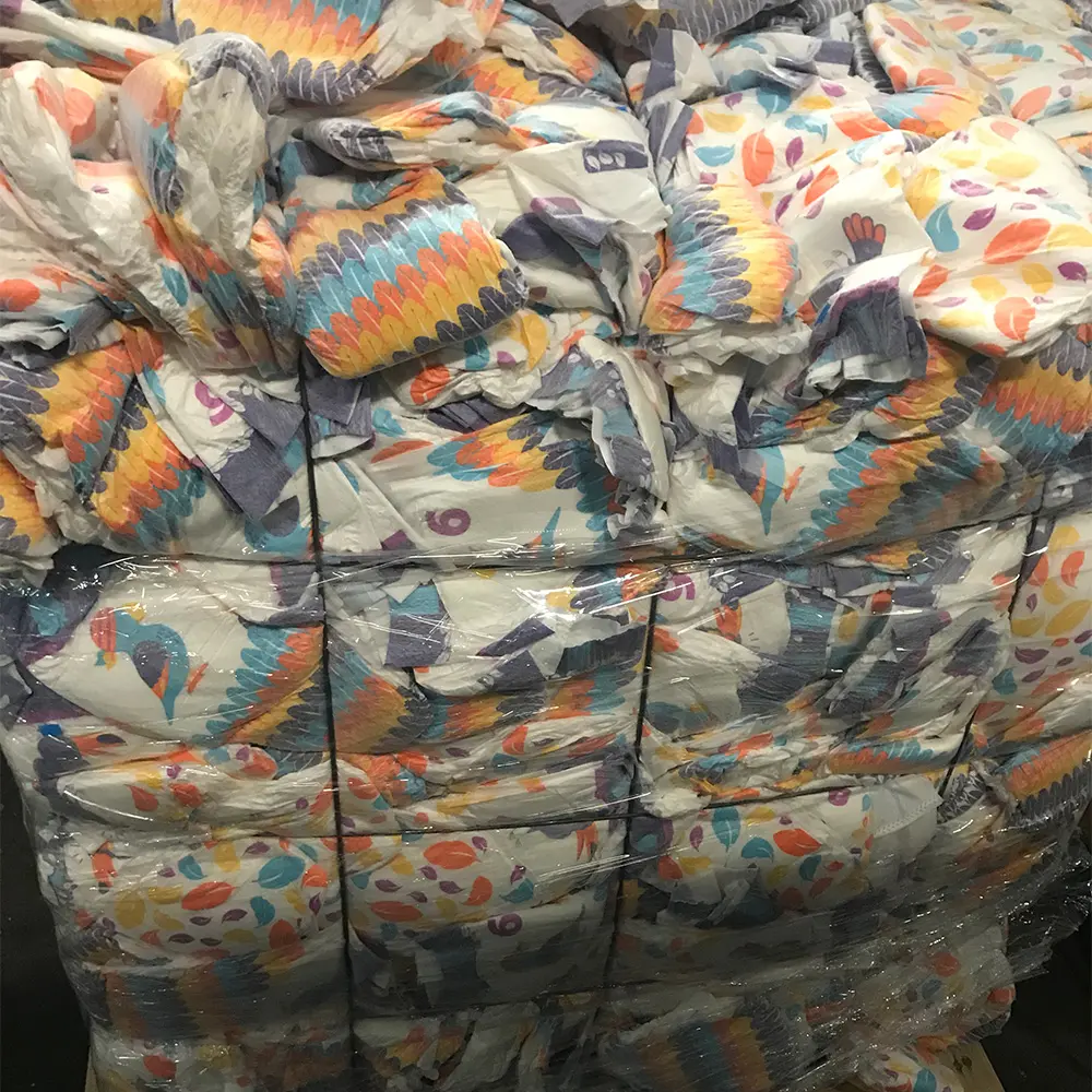 Stack of colorful baby diapers with feather and dotted patterns wrapped in plastic.